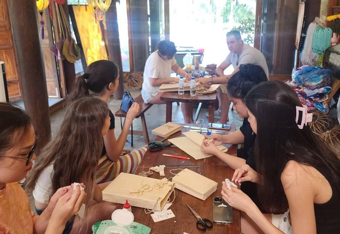 Du khách trải nghiệm tại "Xưởng giấy Việt" của anh Thọ. Ảnh: HOÀNG LIÊN