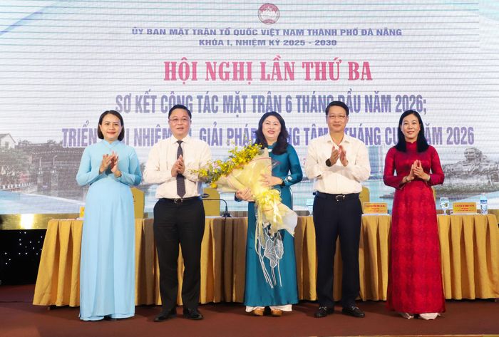 Phó Bí thư Thành ủy Ngô Xuân Thắng (thứ 2, bên phải sang) và Chủ tịch Ủy ban MTTQ Việt Nam thành phố Lê Trí Thanh (thứ 2, bên trái sang) tặng hoa chúc mừng bà Nguyễn Thị Thu Lan. Ảnh: NGỌC PHÚ