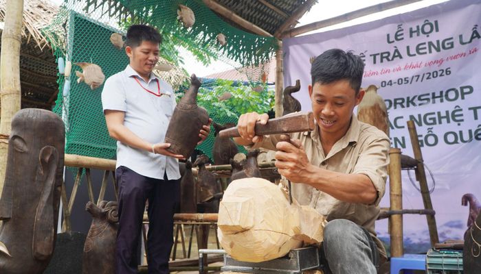 Nghệ nhân biểu diễn nghệ thuật chạm khắc với thân gỗ quế. Ảnh: PHAN VINH