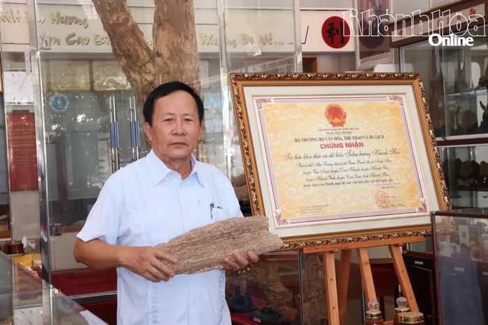 Ông Biện Quốc Dũng bên bảng chứng nhận "Tri thức dân gian khai thác và chế biến trầm hương Khánh Hòa".