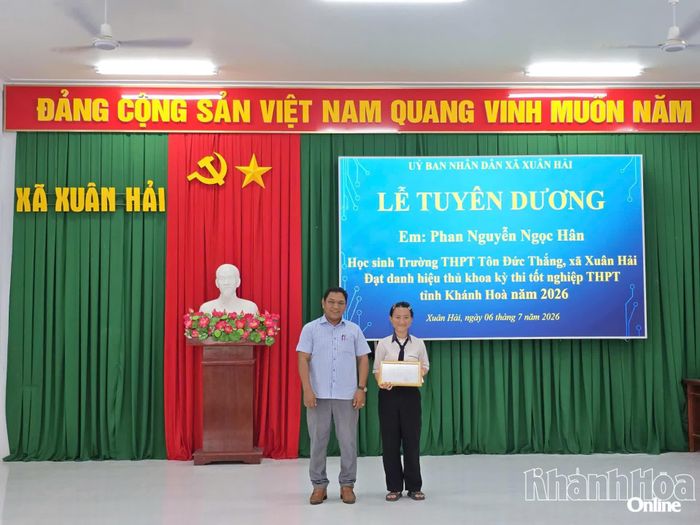 Đại diện Ủy ban MTTQ Việt Nam xã Xuân Hải trao quyết định biểu dương cho em Phan Nguyễn Ngọc Hân.