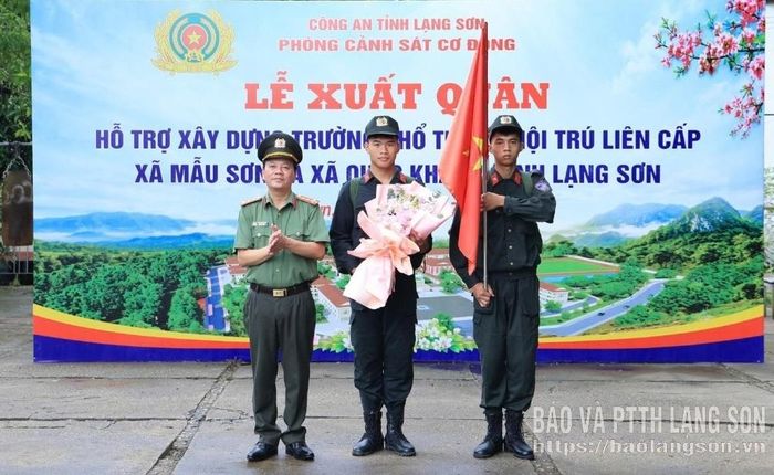 Lãnh đạo Công an tỉnh tặng hoa và trao cờ lệnh cho đại diện các chiến sĩ xuất quân hỗ trợ xây trường