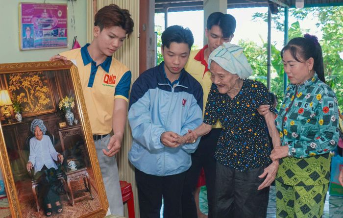 Các bạn sinh viên trao tặng bức ảnh chân dung cho Mẹ Việt Nam Anh hùng Nguyễn Thị Nghiệp