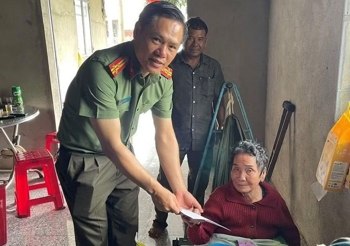 Công an xã Quảng Tân trao tặng phần quà cho cụ Võ Thị Phên.