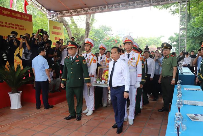 Các vị lãnh đạo thực hiện nghi thức di quan hài cốt liệt sĩ.