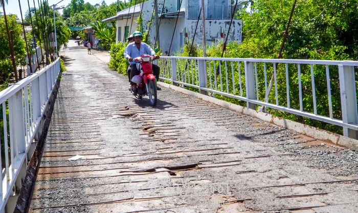 Người dân lưu thông qua cầu luôn thấp thỏm vì mất an toàn, nhất là vào mùa mưa.
