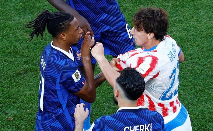 Olise nhận thẻ vàng trong tình huống bị cầu thủ Paraguay khiêu khích. (Ảnh: Reuters)