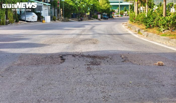 Dọc theo tuyến đường, liên tục xuất hiện những mảng nhựa đường bị cày xới, biến dạng bởi áp lực của dòng xe tải trọng lớn.
