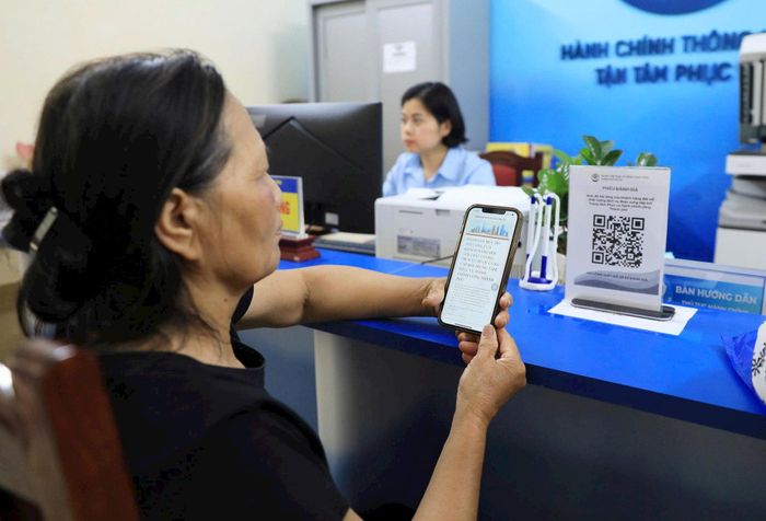 Người dân xã Minh Châu (thành phố Hà Nội) quét mã Qr tìm hiểu thông tin dịch vụ hành chính công. Ảnh: Quang Thái
