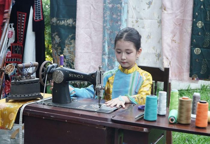 Bạn nhỏ tìm hiểu về không gian may đo áo dài Huế xưa. Ảnh: S.Thùy