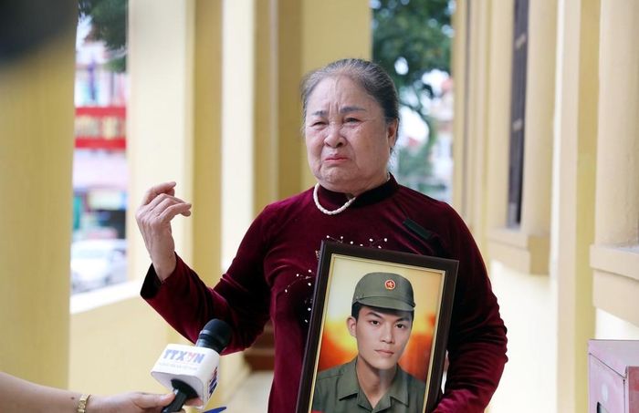 Vợ liệt sĩ Bùi Trung Vững thôn Cù Tu, xã Xuân Trúc (Hưng Yên) xúc động khi nhận được di ảnh của chồng. Ảnh: Thế Duyệt – TTXVN