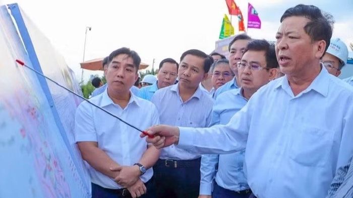 Bộ trưởng Xây dựng Trần Hồng Minh (cầm thước) kiểm tra một dự án đường cao tốc ở khu vực phía nam.