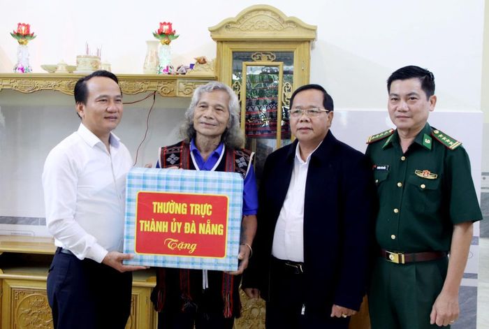 Phó Bí thư Thường trực Thành ủy Nguyễn Đình Vĩnh tặng qua cho già làng Bríu Pố - người có uy tín trong cộng đồng
