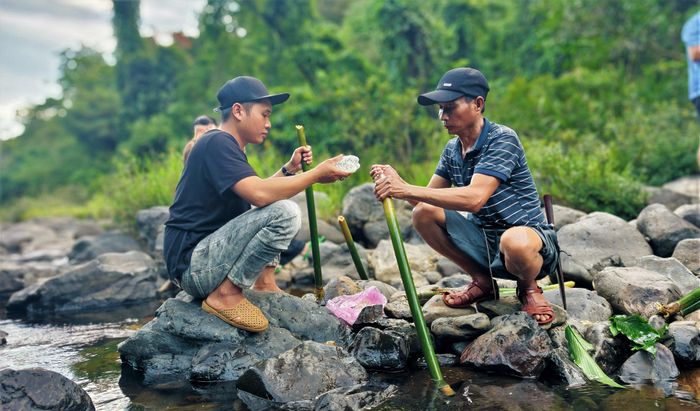  Người dân bản địa nấu cơm bằng ống nứa phục vụ du khách khám phá thác Hang Én 