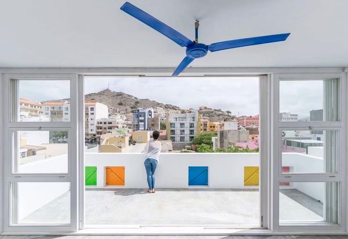 Màu sắc của các cửa sổ có mối liên hệ trực tiếp với bảng màu đã có sẵn trong kiến trúc truyền thống Cabo Verdian, và sự chuyển động của các ô cửa hấp thụ và truyền tải sự năng động và đối thoại với đường phố và trên hết là với hình khối không gian của các tòa nhà lân cận.