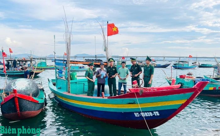Cán bộ, chiến sĩ Đồn Biên phòng Thiên Cầm, Bộ đội Biên phòng tỉnh Hà Tĩnh phát tờ rơi tuyên truyền về khai thác hải sản trên biển cho các tổ tàu thuyền an toàn ở xã Thiên Cầm. Ảnh: Thanh Giang