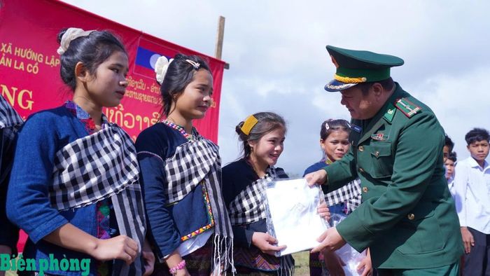 Cán bộ Đồn Biên phòng Hướng Lập trao quà cho học sinh tại bản A Via. Ảnh: Hồ Quý