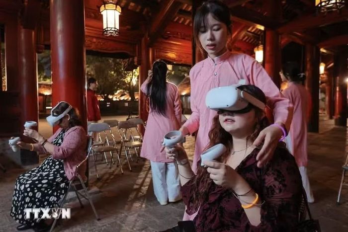 Du khách trải nghiệm viết thư pháp bằng công nghệ số tại Văn Miếu-Quốc Tử Giám. (Ảnh: TTXVN)