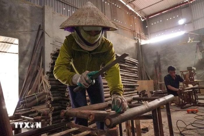 Người thợ tiến hành lắp ghép các chi tiết cho sản phẩm ghế. (Ảnh: Hà Anh/TTXVN phát)