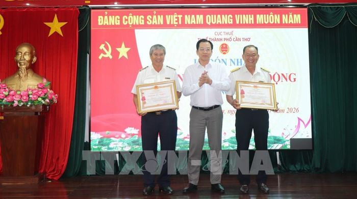 Phó Chủ tịch UBND thành phố Cần Thơ Vương Quốc Nam trao tặng Huân chương Lao động hạng Ba của Chủ tịch nước cho hai cá nhân. Ảnh: Thu Hiền - TTXVN 