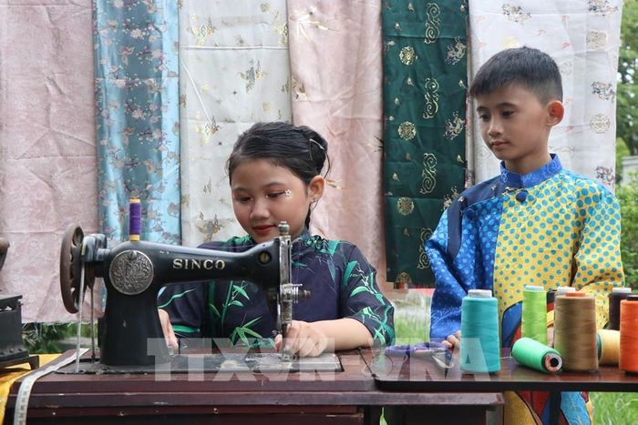 Tham quan Trưng bày, trình diễn “Tri thức may, mặc áo dài Huế”. Ảnh: Mai Trang - TTXVN