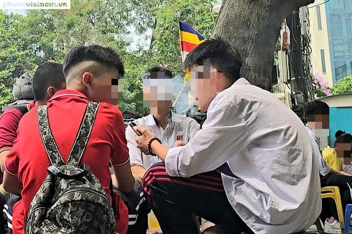 Học sinh tụ tập hút thuốc lá tại một quán trà đá vỉa hè.
