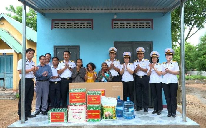 Các đại biểu, cán bộ, chiến sĩ Vùng 4 Hải quân chụp ảnh cùng gia đình được bàn giao nhà. Ảnh: Thanh Hoàng