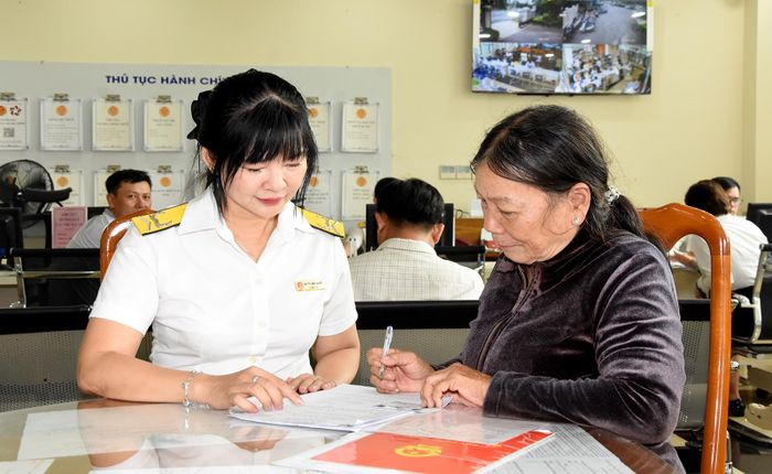 Công chức thuế cơ sở 7 (phường Long Xuyên) hướng dẫn người nộp thuế ghi hồ sơ khai thuế.