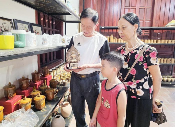 Du khách tham quan, tìm hiểu các sản phẩm quà lưu niệm du lịch tại Trung tâm Bảo tồn tranh dân gian Đông Hồ (phường Thuận Thành).