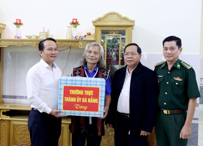 Phó Bí thư Thường trực Thành ủy Nguyễn Đình Vĩnh tặng quà cho già làng Bríu Pố, người có uy tín trong cộng đồng tại xã Tây Giang. Ảnh: TRỌNG HUY