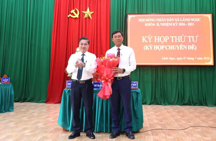 Phó Chủ tịch UBND thành phố Phan Thái Bình (bên trái) tặng hoa chúc mừng tân Chủ tịch UBND xã Lãnh Ngọc Đinh Văn Vũ. Ảnh: N.HƯNG