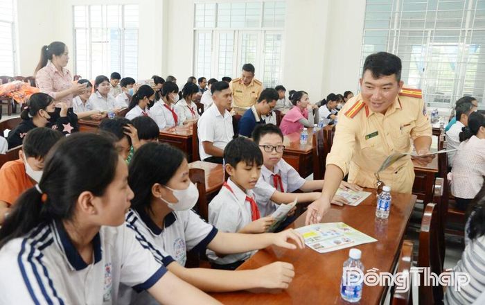 Cán bộ Đội Cảnh sát giao thông đường thủy phát tờ rơi tuyên truyền cho các em học sinh.