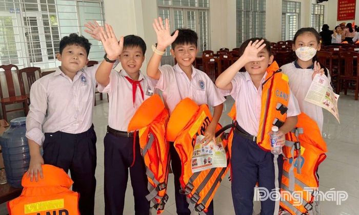 Các em học sinh thích thú bên chiếc áo phao mới của mình.