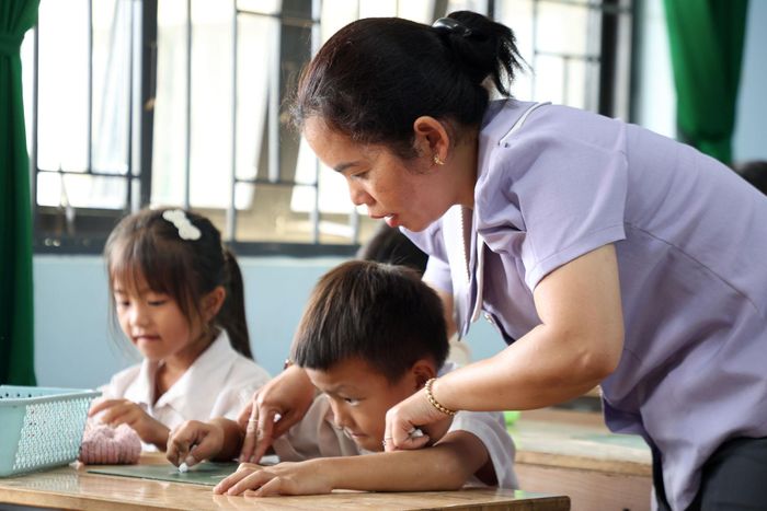 Cô giáo H’Bồm hướng dẫn học sinh viết nét ngang, nét dọc trong những buổi học đầu tiên
