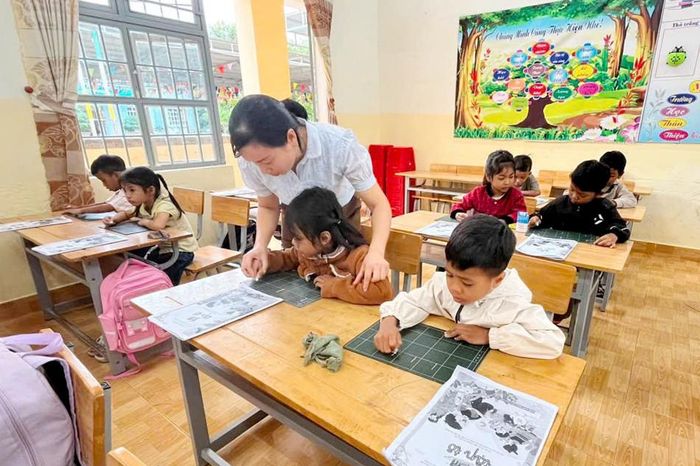 Giáo viên Trường Tiểu học Bằng Lăng hướng dẫn học sinh cầm phấn, viết bảng