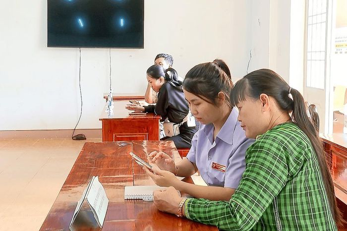Cán bộ Trung tâm Phục vụ hành chính công xã Đắk Sắk hỗ trợ người dân thao tác trên điện thoại thông minh