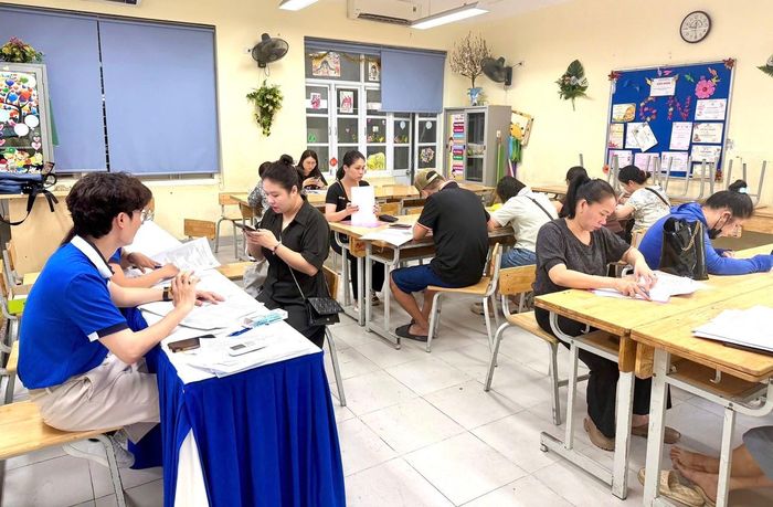 Giáo viên Trường THCS Chương Dương (phường Hồng Hà) hỗ trợ phụ huynh đăng ký tuyển sinh lớp 6 năm học 2026-2027. Ảnh: CTV