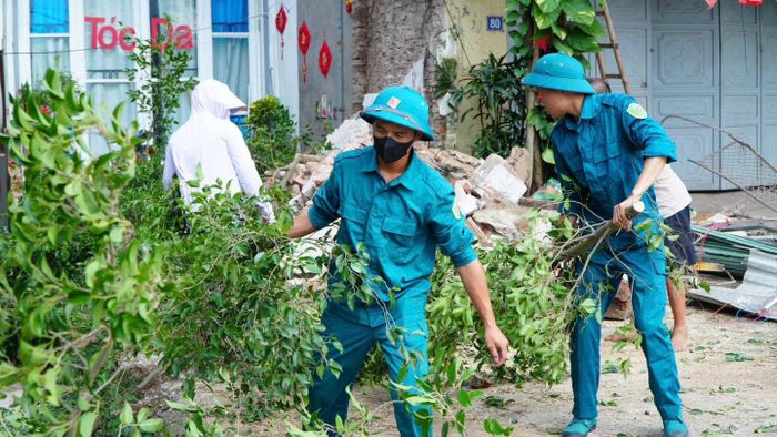 Lực lượng chức năng hỗ trợ người dân trong quá trình giải phóng mặt bằng. Ảnh: DH.