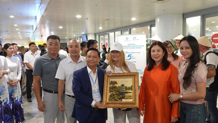 Câu lạc bộ lữ hành UNESCO Hà Nội tặng quà cho vị khách thứ 5 triệu và đoàn khách Tây Ban Nha đến Hà Nội. Ảnh: H.L