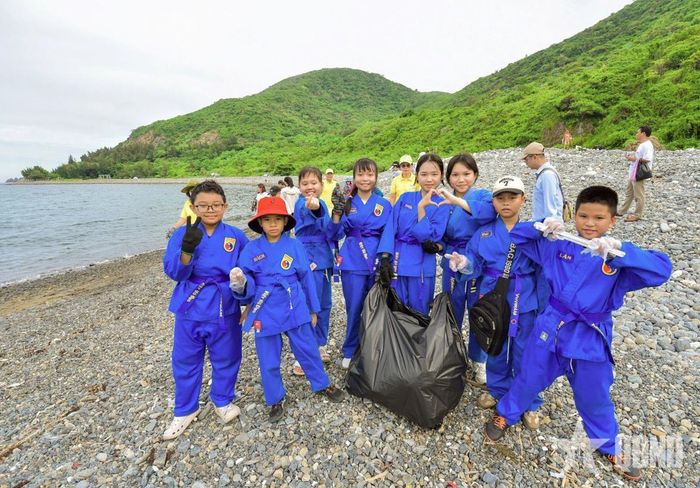 Phụ huynh và các võ sinh Câu lạc bộ Võ thuật Vovinam Vĩnh Hòa tích cực thu gom rác thải làm sạch bãi biển.