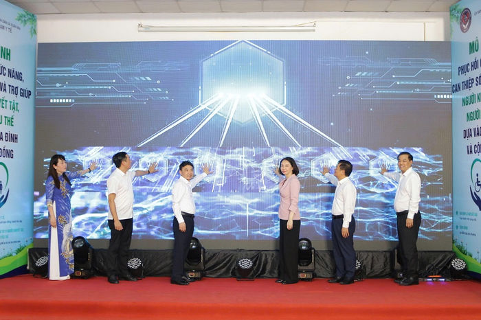 Các đại biểu bấm nút khánh thành mô hình phục hồi chức năng, can thiệp sớm và trợ giúp người khuyết tật, người yếu thế dựa vào gia đình và cộng đồng.