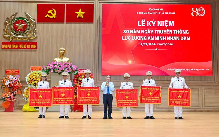 Đồng chí Trần Văn Bảy tặng cờ truyền thống của UBND TPHCM đến 6 tập thể. Ảnh: MẠNH THẮNG