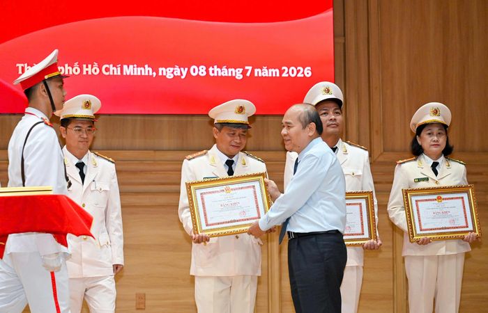Đồng chí Trần Văn Bảy trao bằng khen của UBND TPHCM đến các tập thể. Ảnh: MẠNH THẮNG