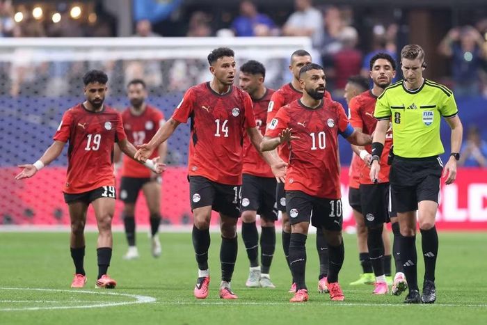 Khu kỹ thuật Ai Cập bùng nổ khi tiền vệ Enzo Fernandez đánh đầu ghi bàn ở phút bù giờ đưa Argentina vượt lên 3-2. Các cầu thủ áo đỏ vây quanh trọng tài Francois Letexier, yêu cầu giải thích vì sao tiền đạo Mohamed Salah không được hưởng phạt đền ở tình huống trước đó. Chỉ khoảng 20 giây sau khi tiếng còi không vang lên ở phần sân Argentina, Ai Cập đã phải nhận nhát dao định mệnh. Đội trưởng Salah dẫn đầu làn sóng phản ứng, khi giấc mơ tạo địa chấn của Ai Cập tan vỡ trong tích tắc. Ảnh: Getty.