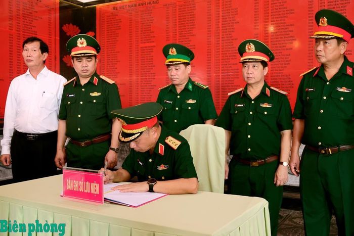 Thượng tướng Lê Quang Minh ghi sổ lưu niệm. Ảnh: Tuấn Kiệt