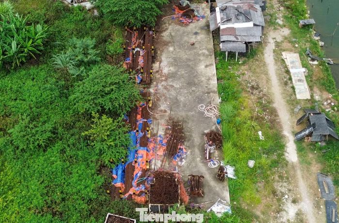 Sắt thép, vật liệu xây dựng trong phạm vi dự án chất đống, phơi mưa, phơi nắng, có dấu hiệu hoen gỉ. Bên trong có một số lán dựng tạm, có công nhân trông coi.