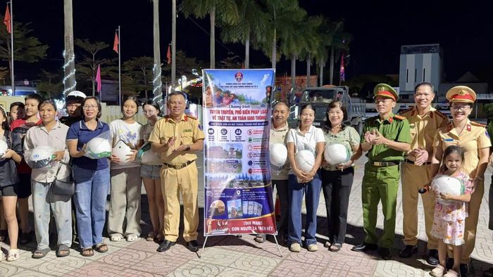 Chương trình tuyên truyền an toàn giao thông kết hợp trao tặng mũ bảo hiểm và hướng dẫn cài quai mũ bảo hiểm đúng cách cho người dân. (Ảnh CA Đà Nẵng)