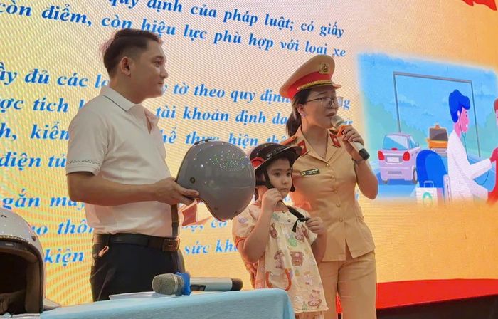 CSGT hướng dẫn học sinh cài quai mũ bảo hiểm đúng cách trong chương trình tuyên truyền an toàn giao thông. (Ảnh CA Đà Nẵng)