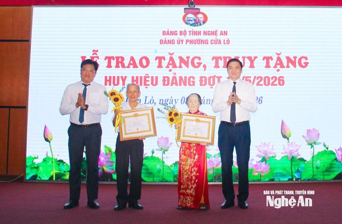 Phó Bí thư Thường trực Tỉnh ủy Hoàng Nghĩa Hiếu và Bí thư Đảng ủy phường Cửa Lò Ngô Đức Kiên trao Huy hiệu 65 năm tuổi Đảng cho các đảng viên. Ảnh: Mai Hoa