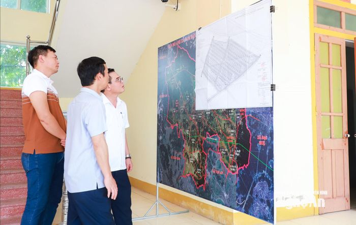 Lãnh đạo xã Nam Đàn trao đổi về hướng tuyến và quy hoạch xây dựng các khu tái định cư dự án cao tốc Vinh - Thanh Thủy đoạn qua địa bàn. Ảnh: Thành Duy